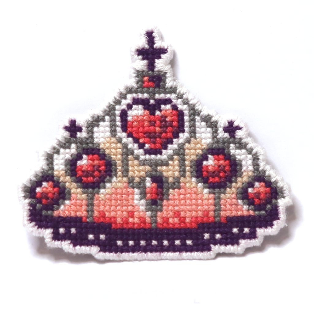 Cross-stitch Barbie-style crown with red hearts and purple details on a white background.