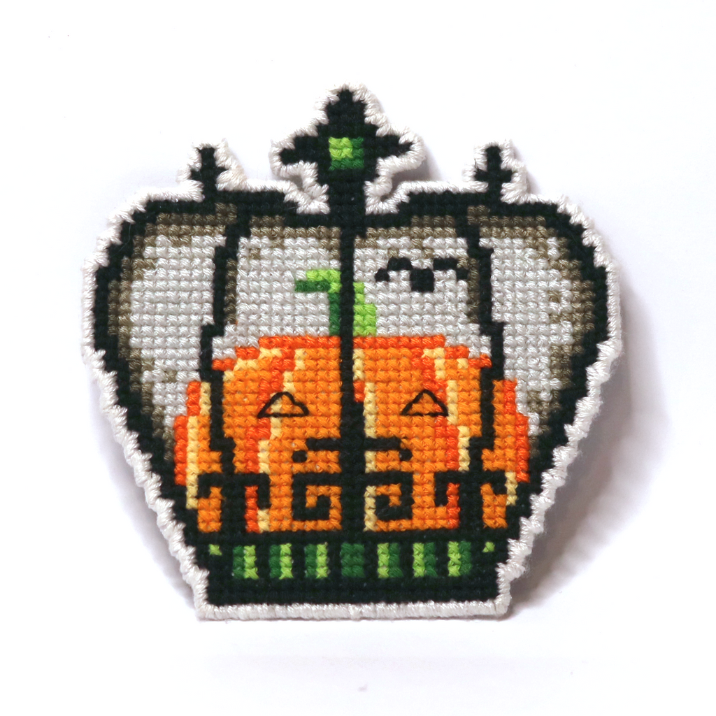 Cross-stitch Halloween crown in gray, orange, and green with a pumpkin and bird in Tim Burton style.