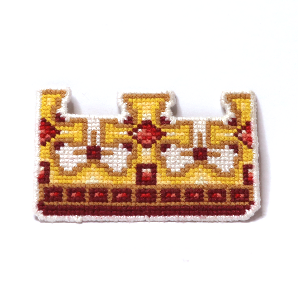 Cross-stitch king’s crown in yellow, orange, red, and brown with a classic royal design.