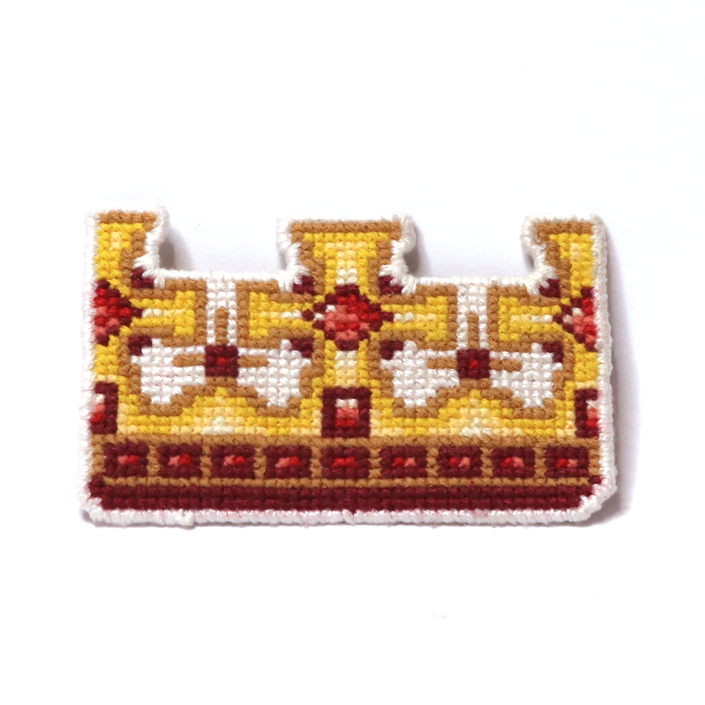 Cross-stitch king’s crown in yellow, orange, red, and brown with a classic royal design.