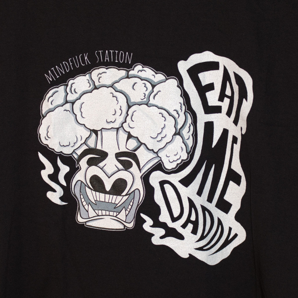 Close-up of the broccoli graphic and Eat Me Daddy lettering on the black T-shirt