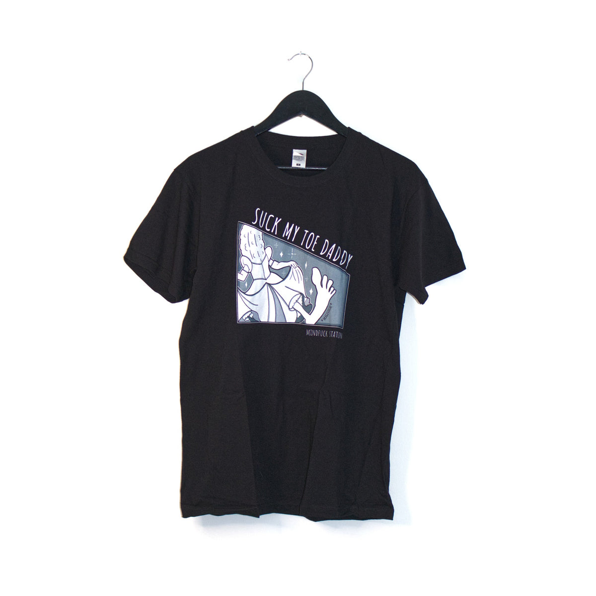 Black MindfuckStation Suck My Toe Daddy T-shirt on a hanger, showing the front graphic