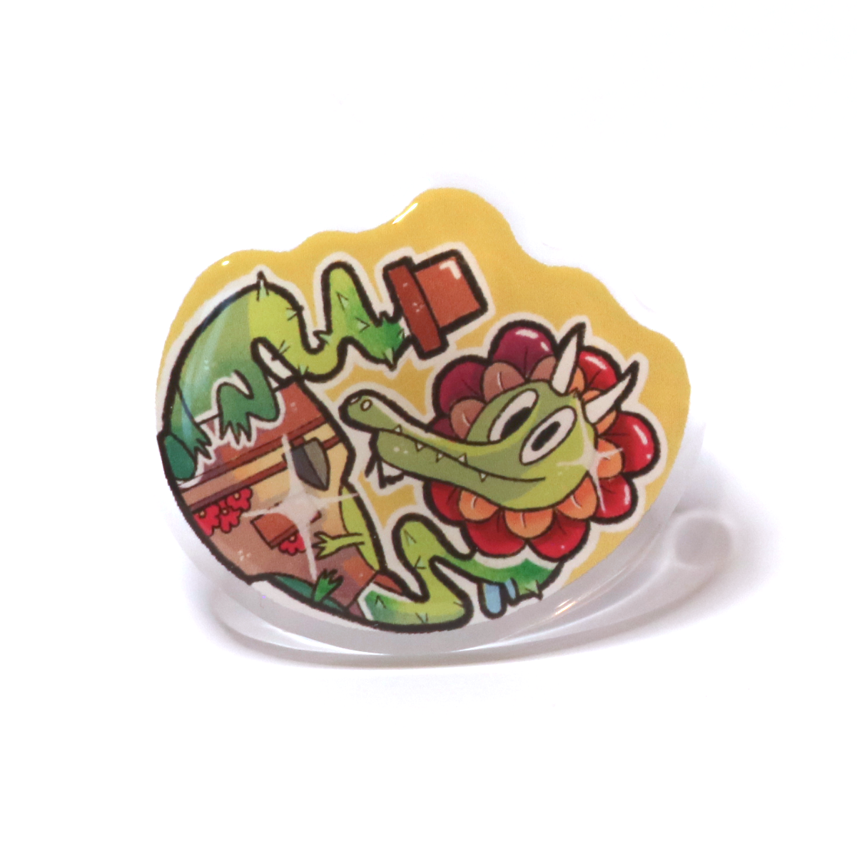 Acrylic pin of a plant dragon growing from a flower pot, wearing a gardening apron with tools, a flower around its head, and rose-like thorns.