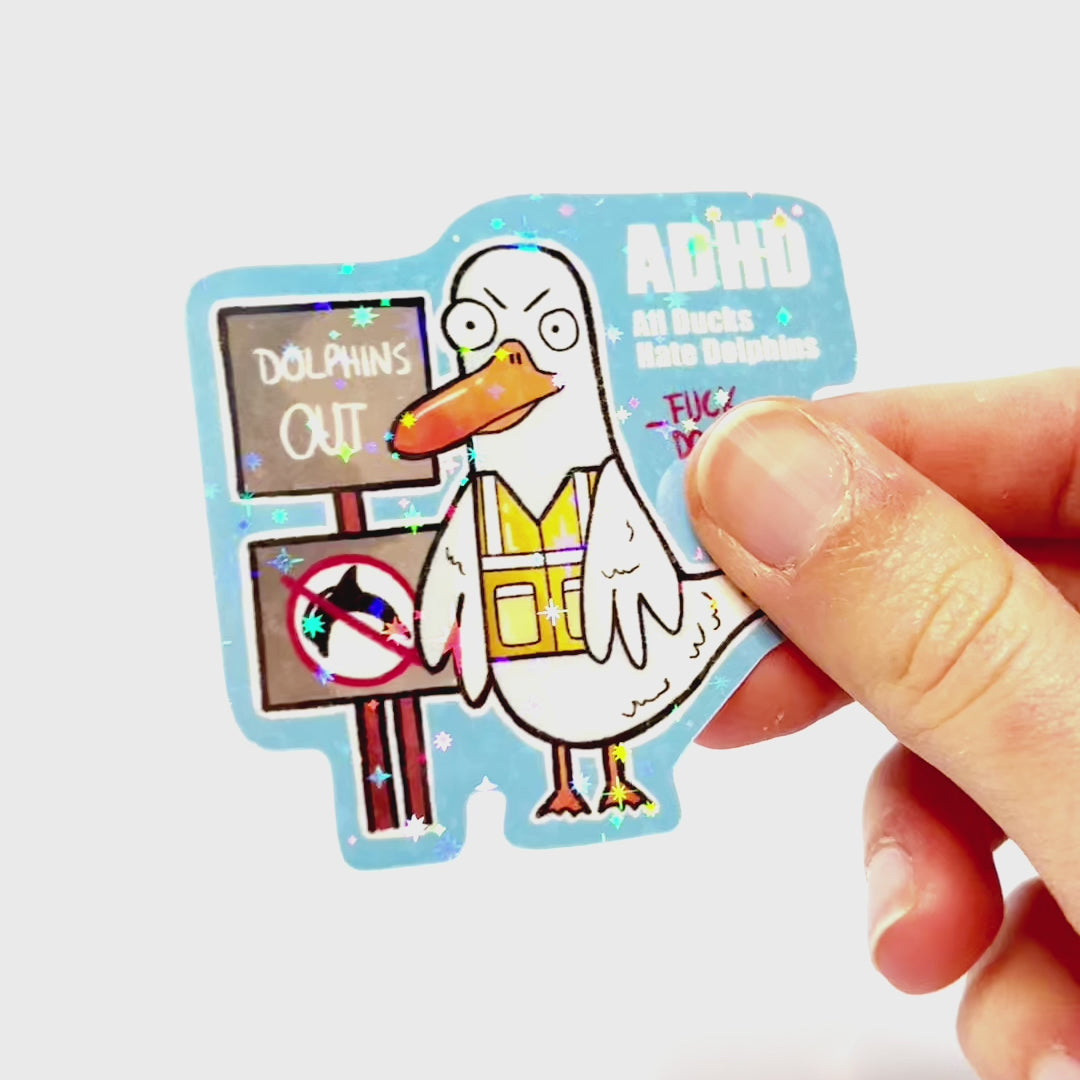 Video: Sticker of an angry duck in a safety vest protesting with signs against dolphins, with the slogan ‘ADHD – All Ducks Hate Dolphins.’